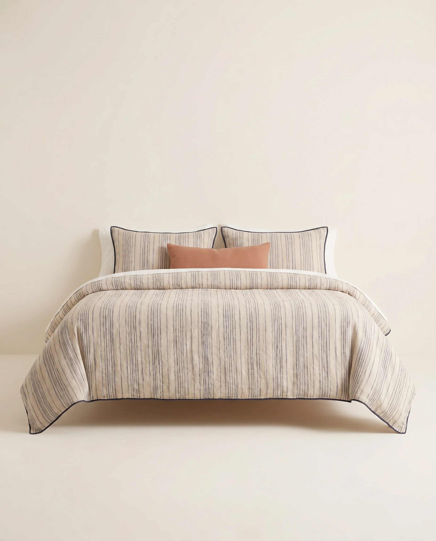 AI bedding ecommerce concept image with a striped duvet set on a neutral studio background