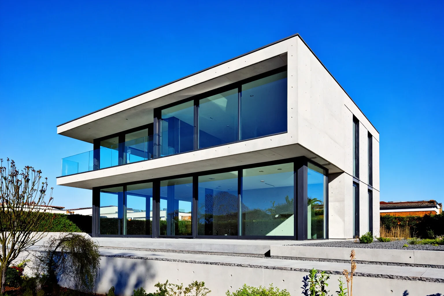 Exemple d’architecture montrant un bâtiment résidentiel moderne avec béton, verre et encadrement en métal noir