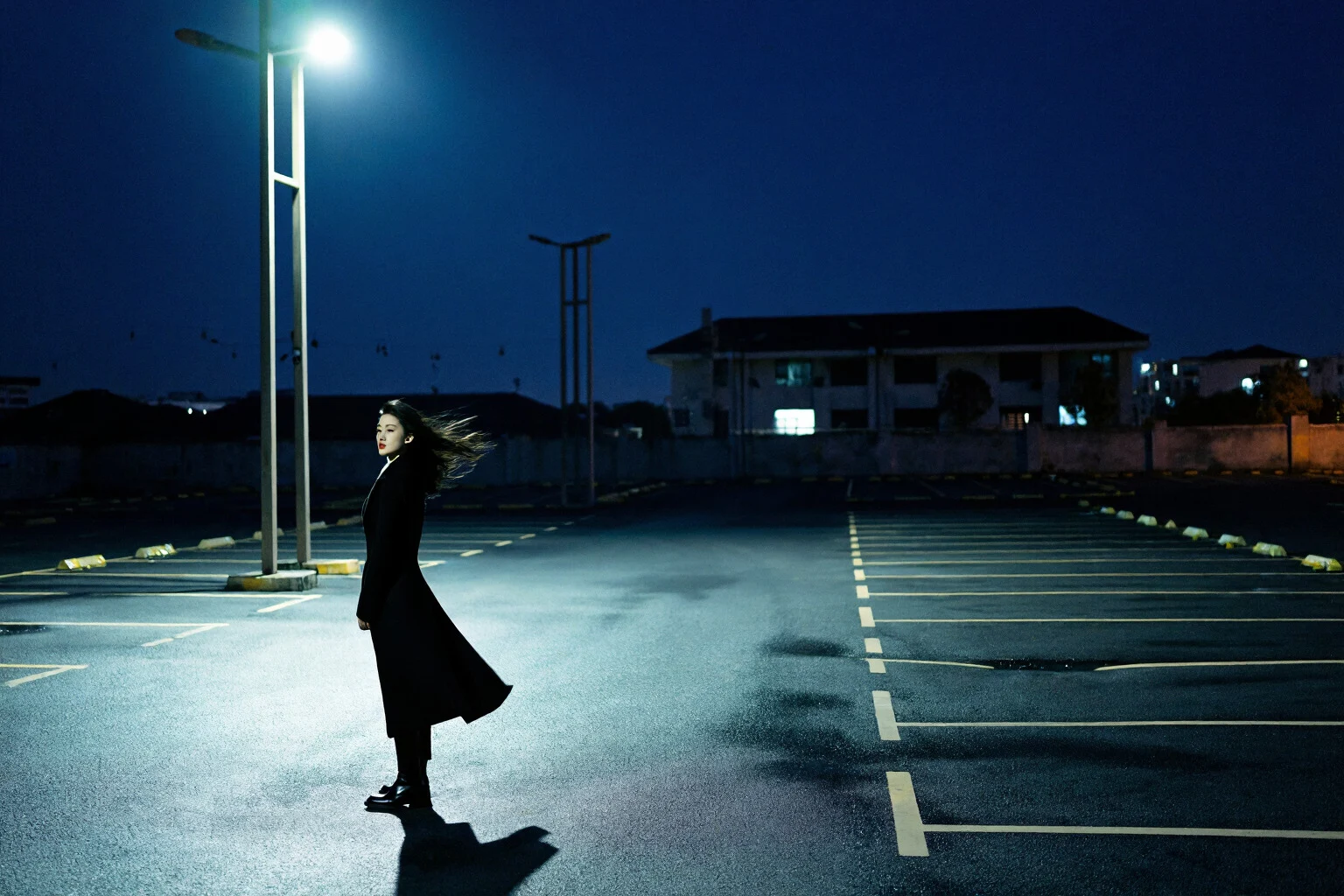 Exemple de personnage cinématique montrant une femme sous un lampadaire dans un parking vide